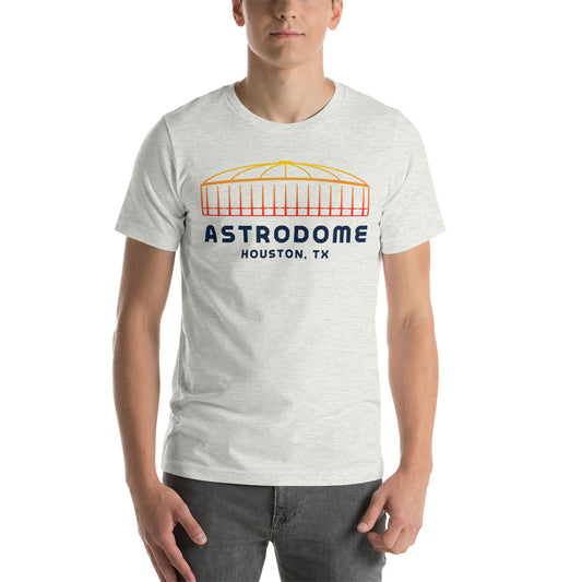 Image of man wearing heather ash t-shirt with design of "Astrodome, Houston, TX" illustrated ballpark completed in retro Houston Astros tequila sunrise colours located on centre chest. This design is exclusive to Tailgate Mercantile and available only online.