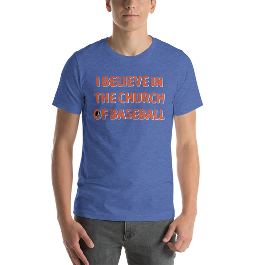 This image details the graphic design with the words "I believe in the church of baseball" with an image of a bull coming out of the O in "of". This shirt is an homage to the baseball movie Bull Durham featuring Kevin Costner and Susan Sarandon. This design is exclusive to Tailgate Mercantile and available only online. In this specific image, the shirt is being modelled on a young man.