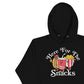 Image of black hoodie with design of "Here For The Snacks" with cartoon hot dog, soda pop and popcorn located on centre chest. This design is exclusive to Tailgate Mercantile and available only online.