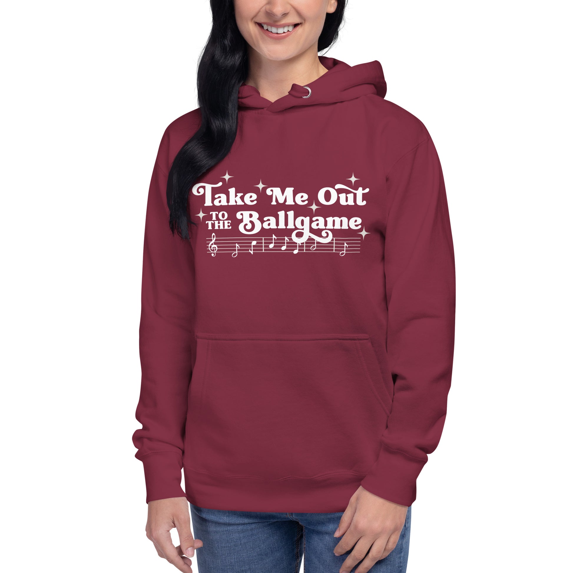 Image of woman wearing dark raspberry hoodie with design of "Take Me Out to the Ballgame" with coordinating musical notes in white located on centre chest. This design is exclusive to Tailgate Mercantile and available only online.
