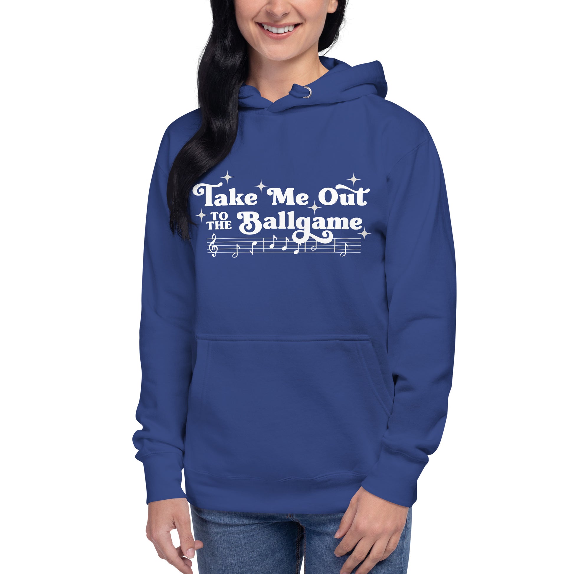 Image of woman wearing royal blue hoodie with design of "Take Me Out to the Ballgame" with coordinating musical notes in white located on centre chest. This design is exclusive to Tailgate Mercantile and available only online.