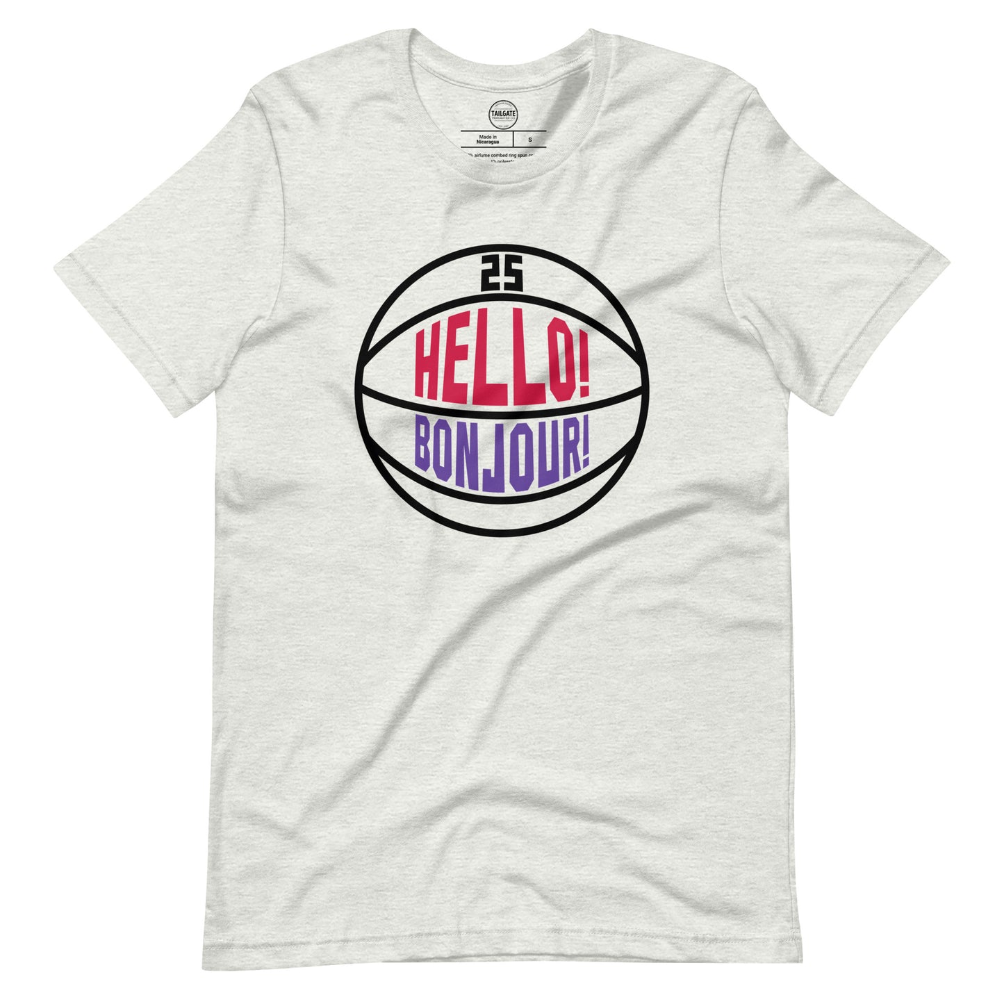This image details the graphic design "Hello! Bonjour!". In the image, the words are built into a basketball and feature Chris Boucher's number 25. The Toronto Raptors' announcer, Jack Armstrong, loves to shout out Hello! Bonjour! when Chris Boucher does something exciting on the court. The tee is heather ash and the design is black/red/purple similar to the Toronto Raptors retro colours. This item is exclusive to tailgate mercantile and is available only online.