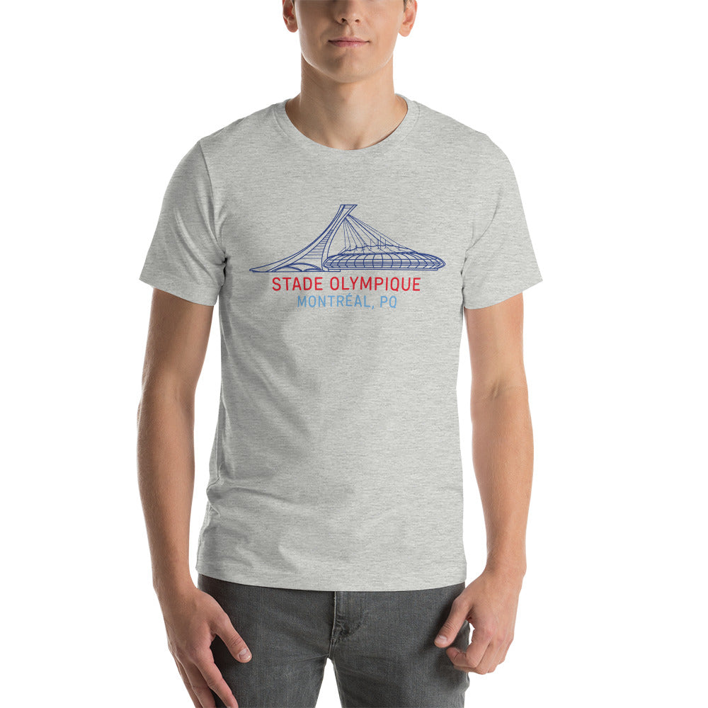 Image of man wearing heather athletic grey t-shirt with design of "Stade Olympique, Montreal, PQ" illustrated ballpark completed in retro Montreal Expos colours located on centre chest. This design is exclusive to Tailgate Mercantile and available only online.