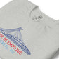 Close up image of heather athletic grey t-shirt with design of "Stade Olympique, Montreal, PQ" illustrated ballpark completed in retro Montreal Expos colours located on centre chest. Image includes neck tag information. This design is exclusive to Tailgate Mercantile and available only online.