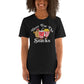 Image of young woman wearing heather black tee with design of "Here For The Snacks" with cartoon hot dog, soda pop and popcorn located on centre chest. This design is exclusive to Tailgate Mercantile and available only online.