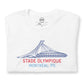 Close up image of white t-shirt with design of "Stade Olympique, Montreal, PQ" illustrated ballpark completed in retro Montreal Expos colours located on centre chest. This design is exclusive to Tailgate Mercantile and available only online.
