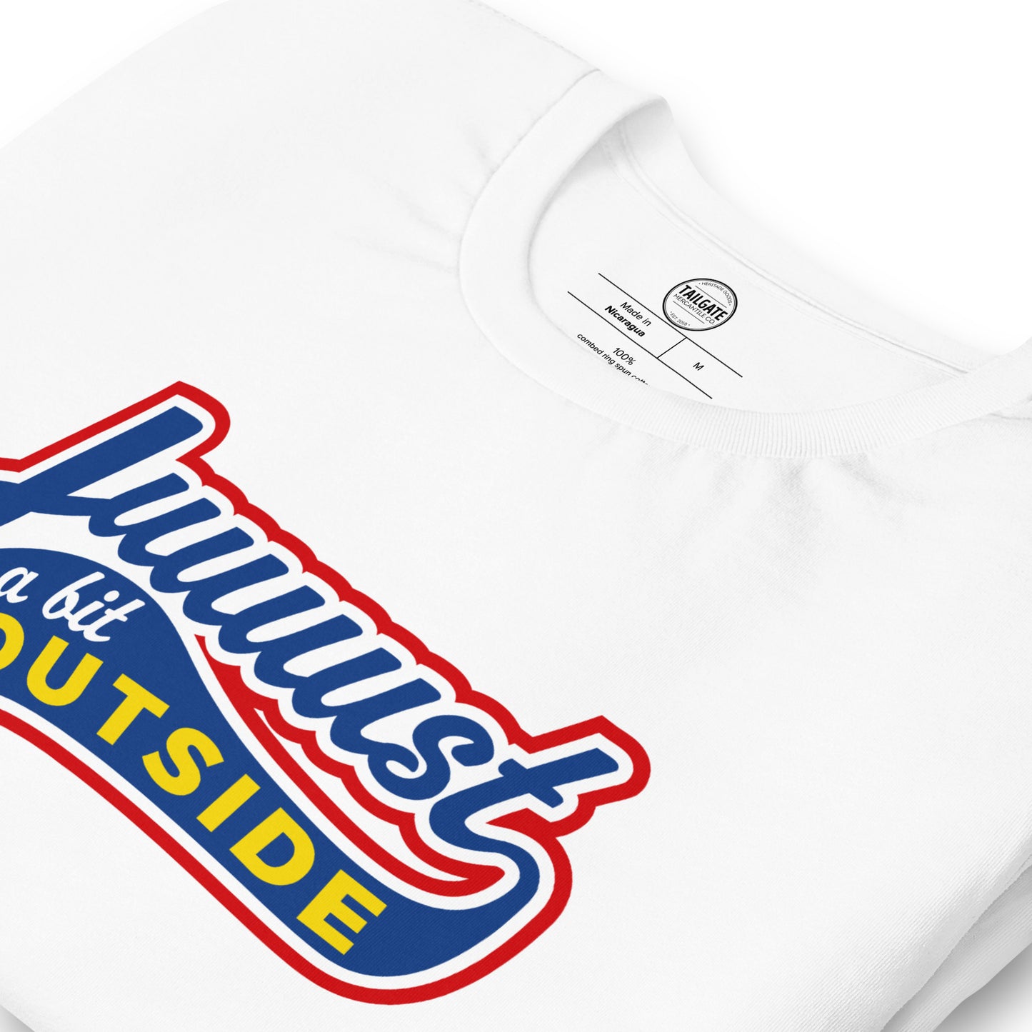 Close up image of white t-shirt with design of "Juuuust a bit Outside" in blue/red/yellow located on centre chest. Just a Bit Outside is an homage to the great baseball movie "Major League". Image includes neck tag information. This design is exclusive to Tailgate Mercantile and available only online.